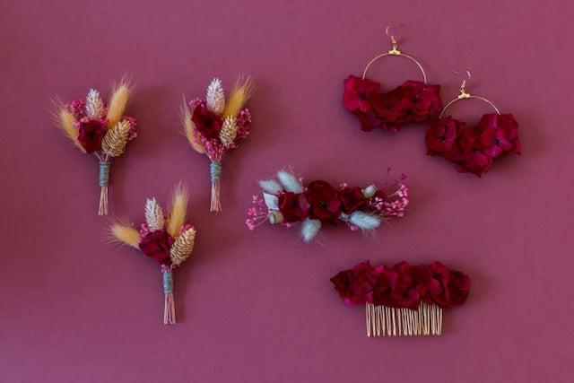 collection d'accessoires en fleurs sèches : 3 boutonnières, une paire de boucle d'oreilles, une barrette à cheveux et un peigne à chignon